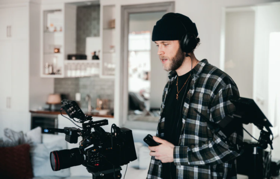 man in black and white plaid dress shirt holding black dslr camera photo